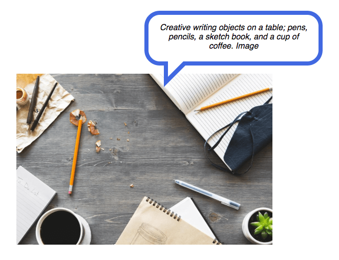 Image on a web page with text bubble, 'Creative writing objects on a table; pens, pencils, a sketch book, and a cup of coffee. Image'