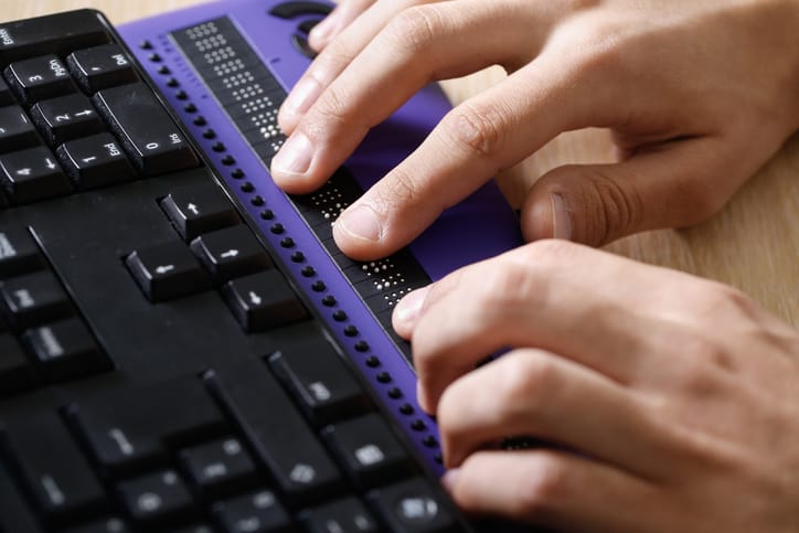 A person using a braille reader.